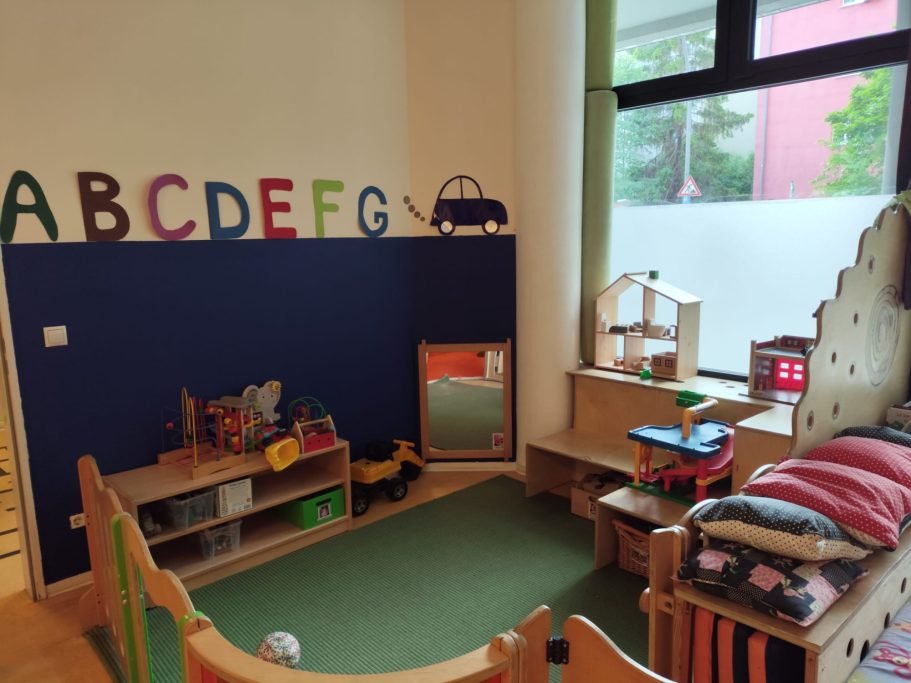 Spielecke mit Bücherregal, Puppenhaus und bunten Buchstaben